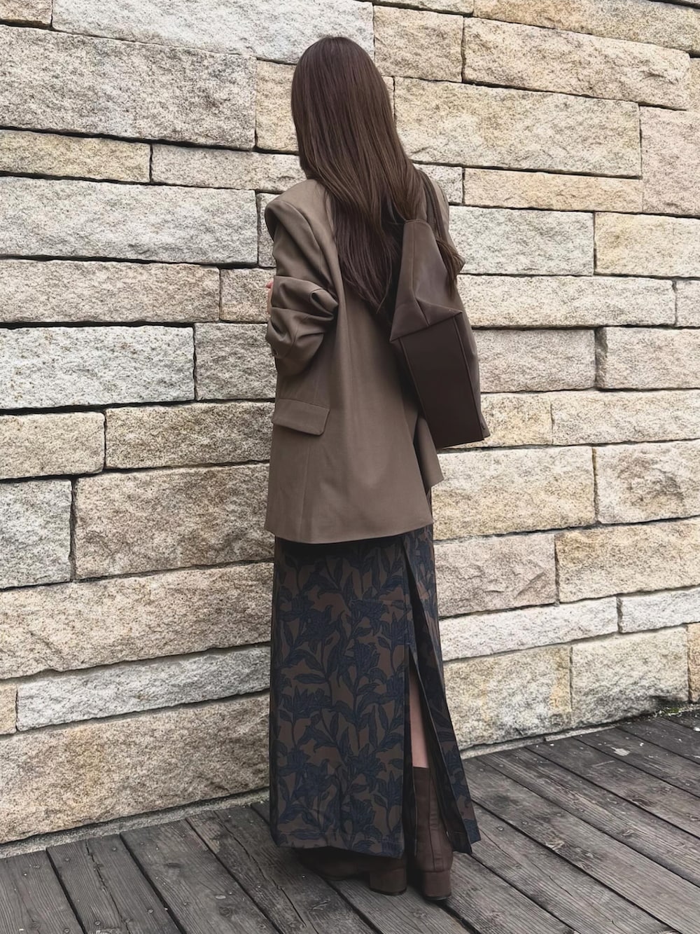ブラウン系のブーツ、その他のテーラードジャケット、ブラウン系のスカートを着用したレディースの秋コーディネートの3枚目の写真