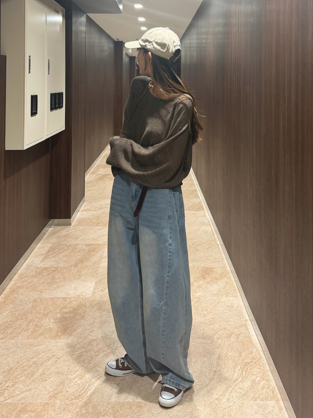 ブラウン系のニット/セーター、ブラウン系のスニーカー、ベージュ系のキャップを着用したレディースの春コーディネートの4枚目の写真