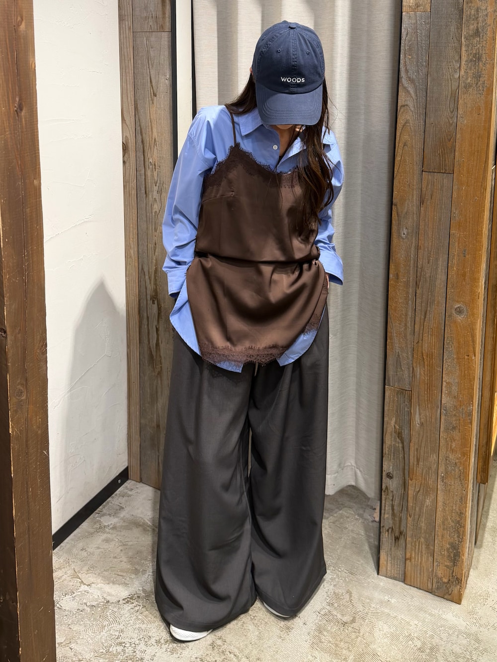 ブラウン系のキャミソール、グレー系のスラックス、ブルー系のキャップを着用したレディースの春コーディネートの3枚目の写真