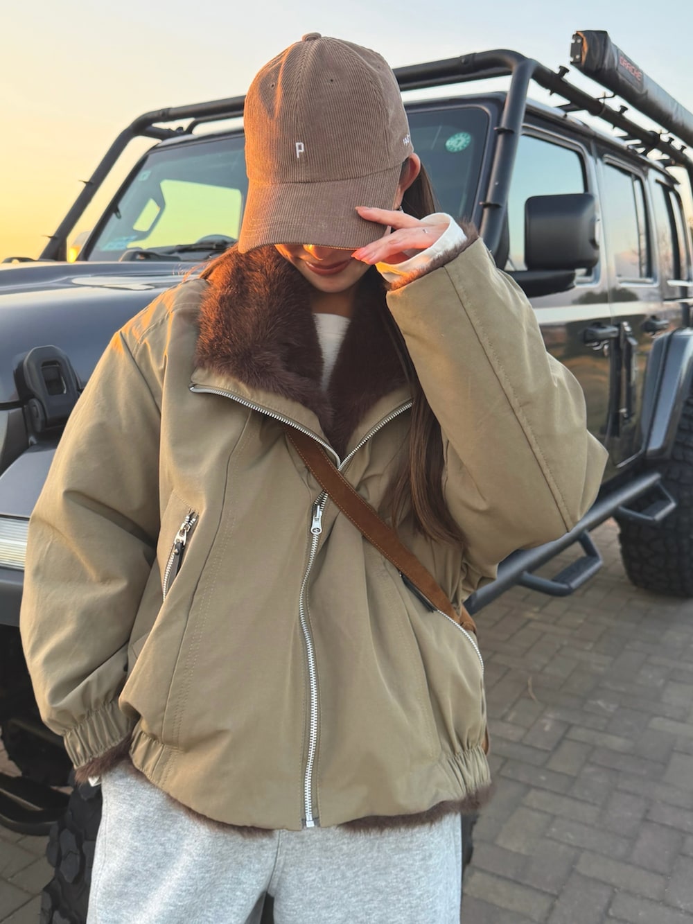 グリーン系のブルゾン、グレー系のスウェットパンツを着用したレディースの冬コーディネートの4枚目の写真