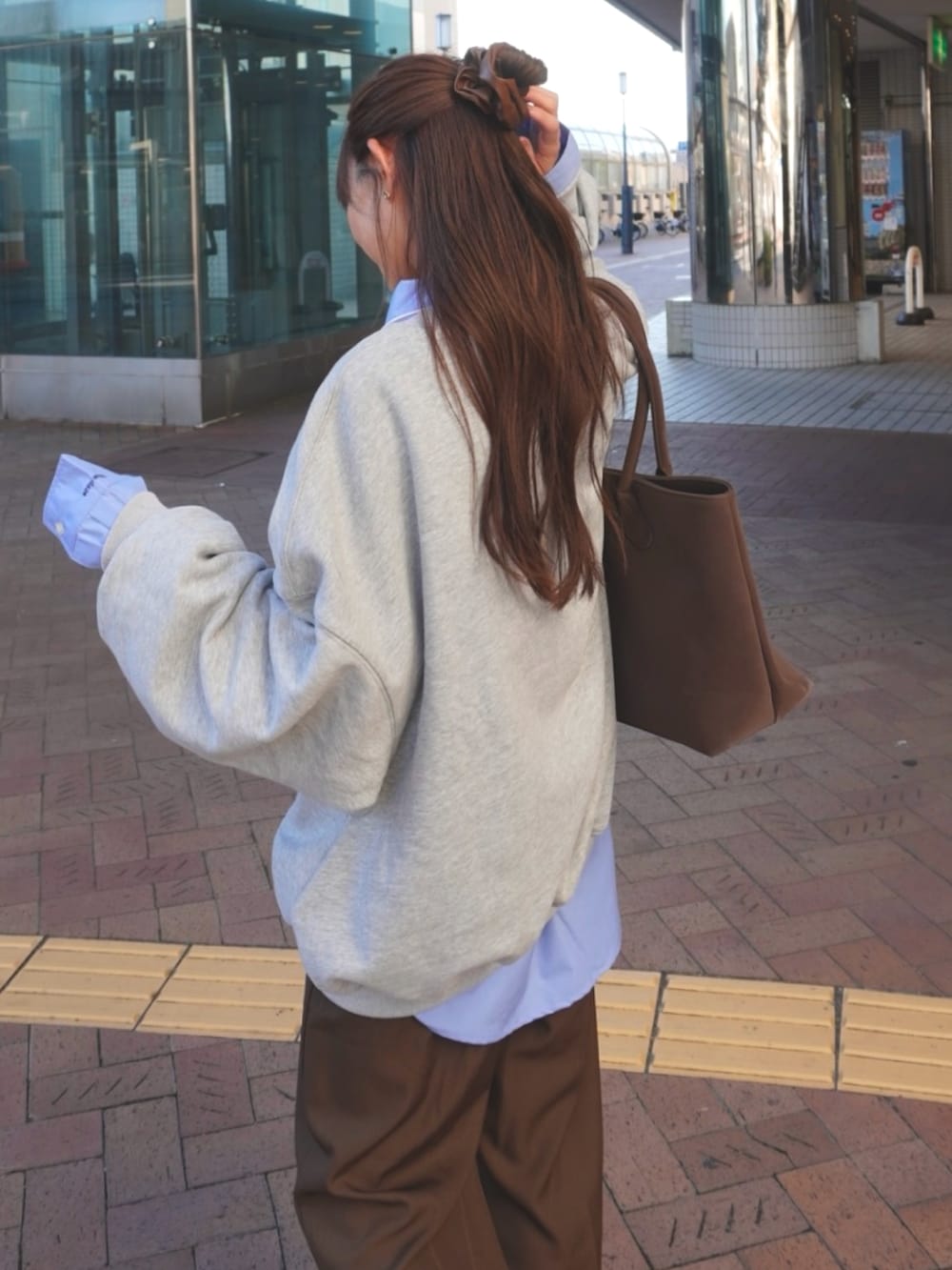 グレー系のスウェット、ブルー系のシャツ/ブラウスを着用したレディースの秋コーディネートの3枚目の写真