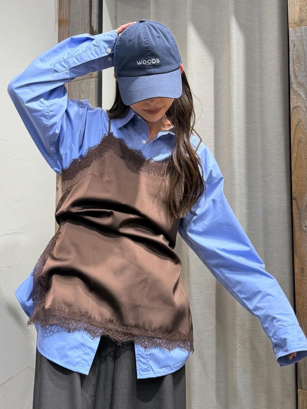 ブラウン系のキャミソール、グレー系のスラックス、ブルー系のキャップを着用したレディースの春コーディネートの4枚目の写真