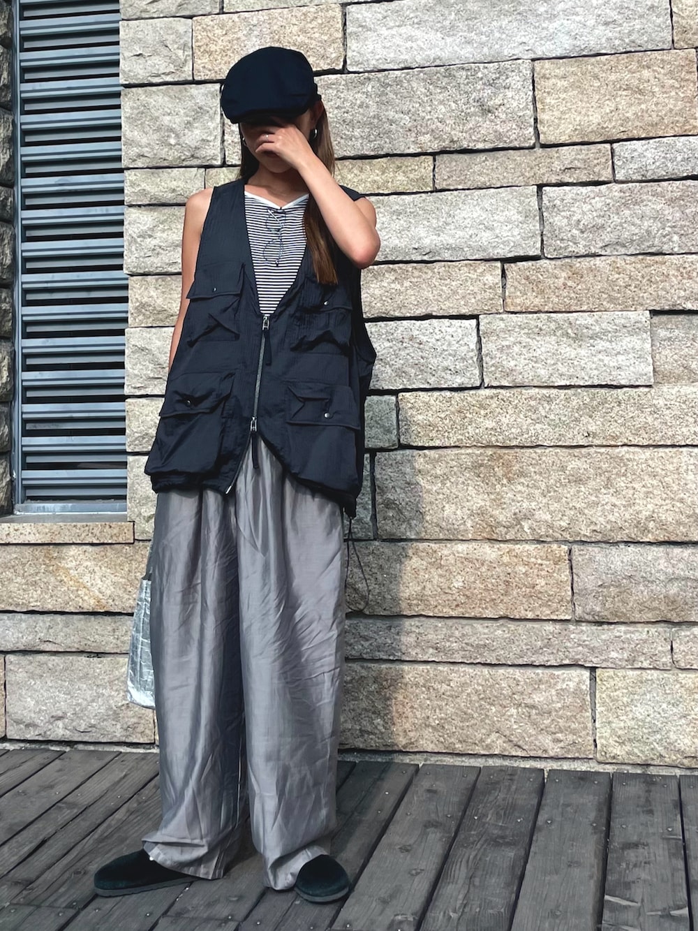 ブラック系のベスト、グレー系のパンツ、ブラック系のスリッポンを着用したレディースの秋コーディネートの3枚目の写真