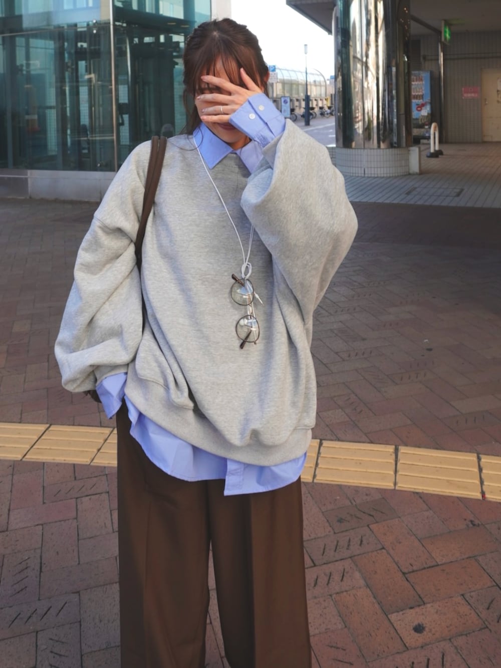 グレー系のスウェット、ブルー系のシャツ/ブラウスを着用したレディースの秋コーディネートの2枚目の写真