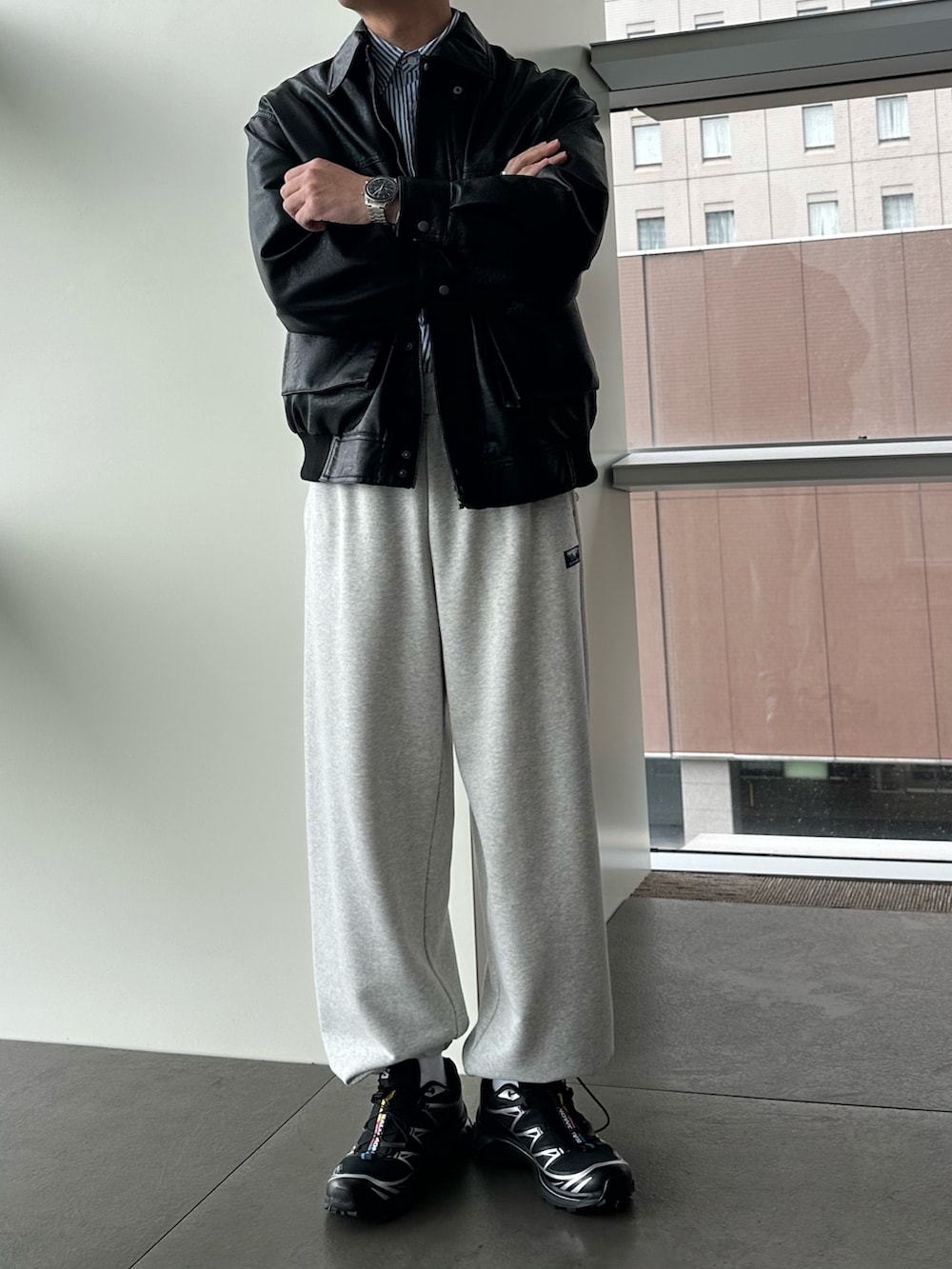 ブラック系のブルゾン、グレー系のスウェットパンツ、ブラック系のスニーカーを着用したメンズの秋コーディネートの2枚目の写真