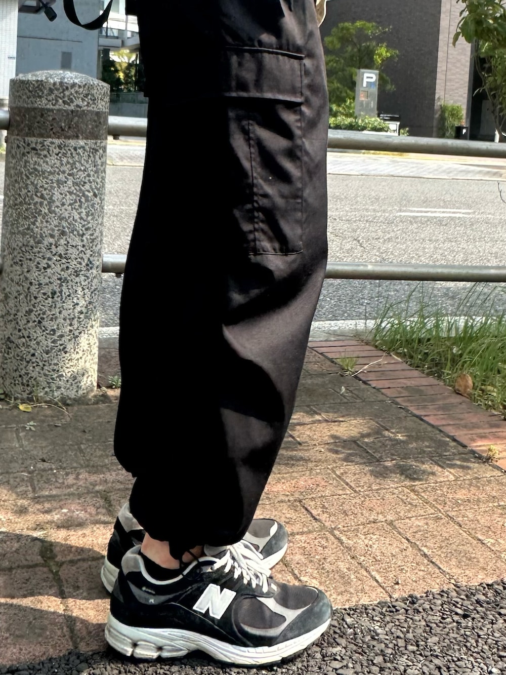 ベージュ系のTシャツ/カットソー、ホワイト系のバックパック/リュック、ブラック系のカーゴパンツを着用したメンズの夏コーディネートの4枚目の写真