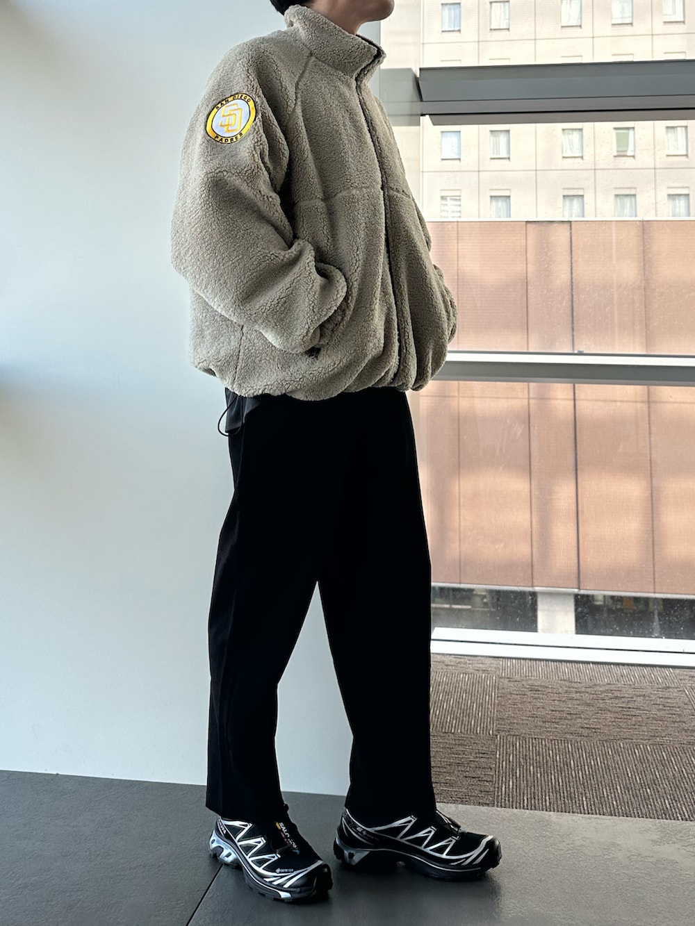 ブラウン系のブルゾン、ブラック系のスニーカーを着用したメンズの秋コーディネートの2枚目の写真