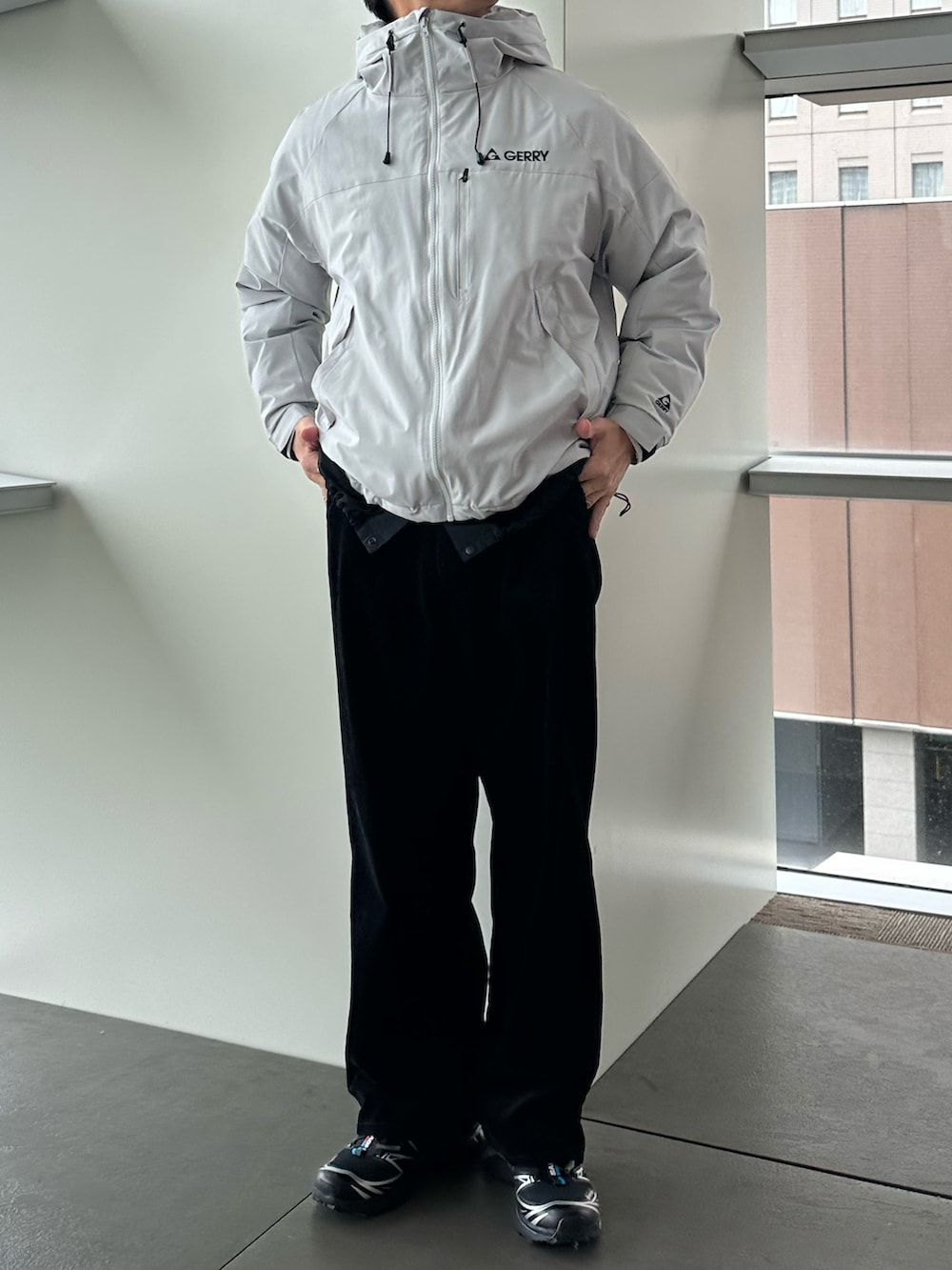 グレー系のダウンジャケット/コート、ブラック系のその他パンツ、ブラック系のスニーカーを着用したメンズの秋コーディネートの2枚目の写真