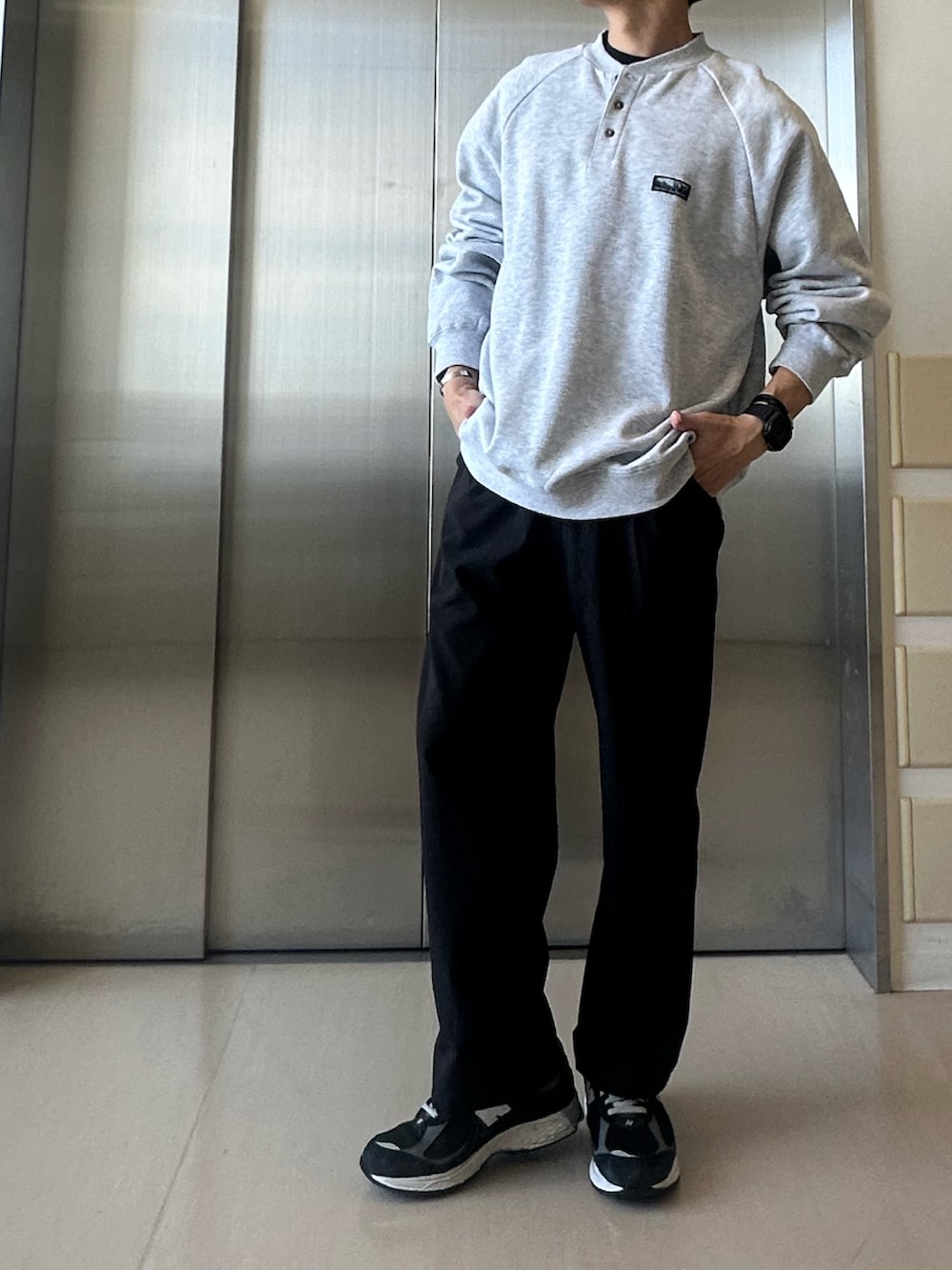 グレー系のスウェット、ブラック系のその他パンツ、ブラック系のスニーカーを着用したメンズの秋コーディネートの2枚目の写真