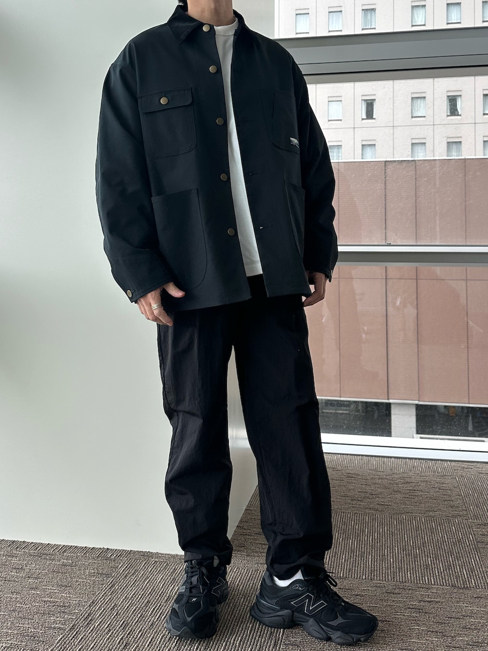 ブラック系のカバーオール、ホワイト系のTシャツ/カットソー、ブラック系のカーゴパンツを着用したメンズの秋コーディネートの2枚目の写真