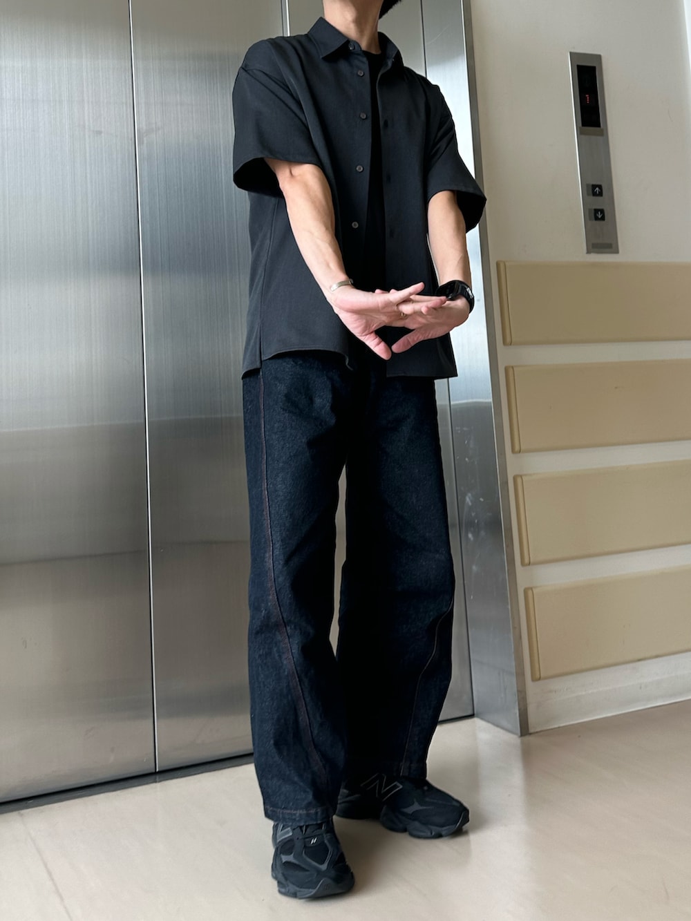ブルー系のデニムパンツ、グレー系のシャツ/ブラウス、ブラック系のスニーカーを着用したメンズの秋コーディネートの2枚目の写真