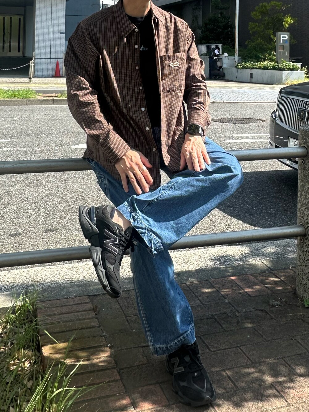 ブラウン系のシャツ/ブラウス、ブラック系のスニーカー、ブルー系のデニムパンツを着用したメンズの夏コーディネートの2枚目の写真