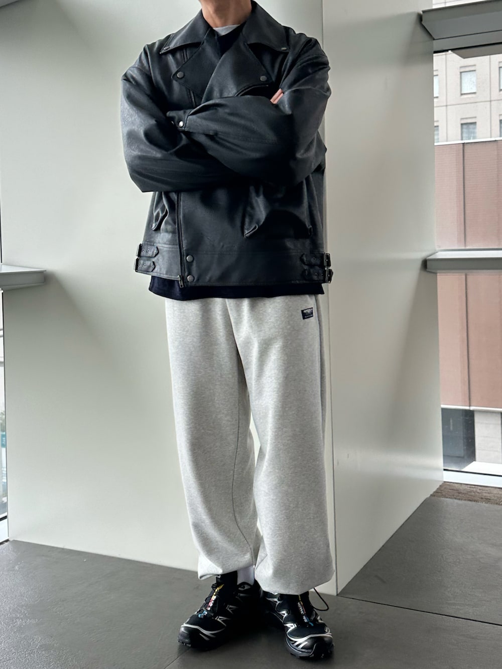 グレー系のライダースジャケット、グレー系のスウェットパンツ、ブラック系のスニーカーを着用したメンズの秋コーディネートの2枚目の写真
