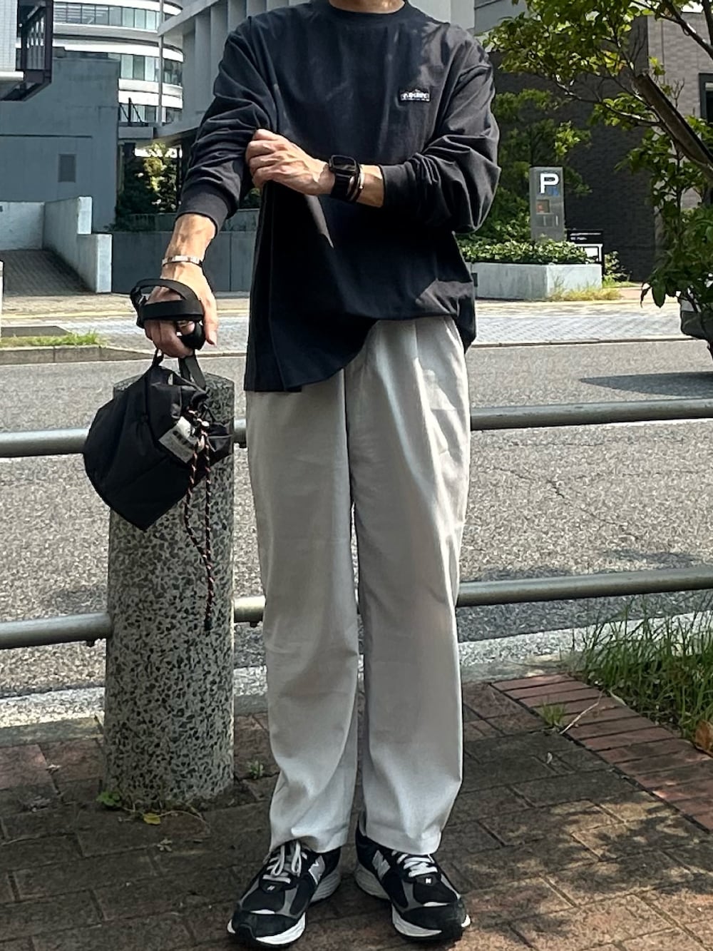 ブラック系のスニーカー、グレー系のその他パンツ、ブラック系のショルダーバッグを着用したメンズの夏コーディネートの2枚目の写真