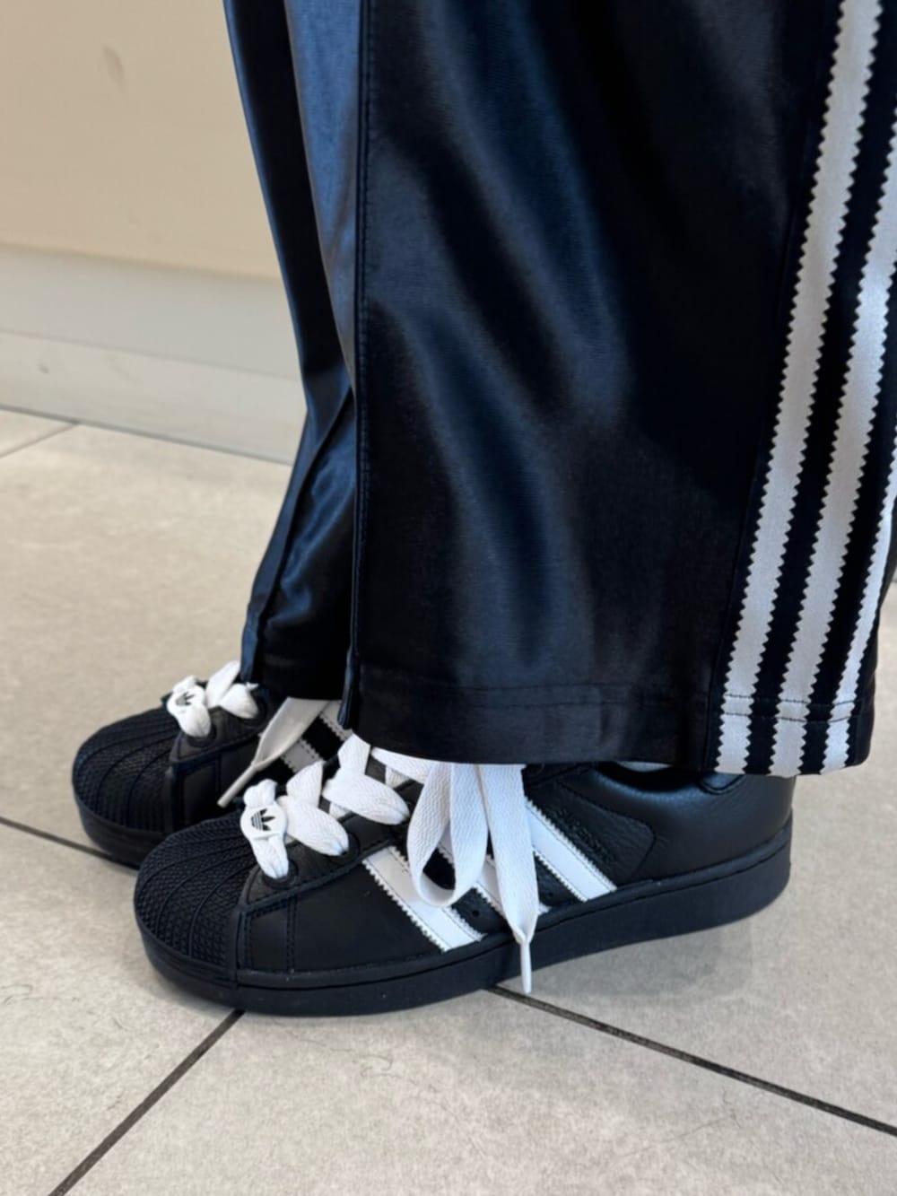 ブラック系のスニーカー、ホワイト系のシャツ/ブラウス、ブラック系のその他パンツを着用したレディースの春コーディネートの2枚目の写真