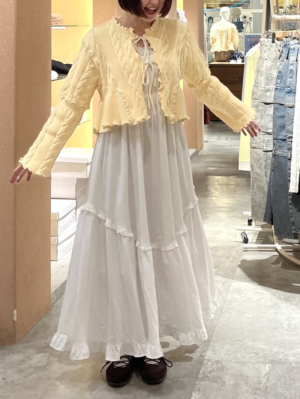 ホワイト系のワンピース、イエロー系のカーディガン/ボレロを着用したレディースの春コーディネートの3枚目の写真