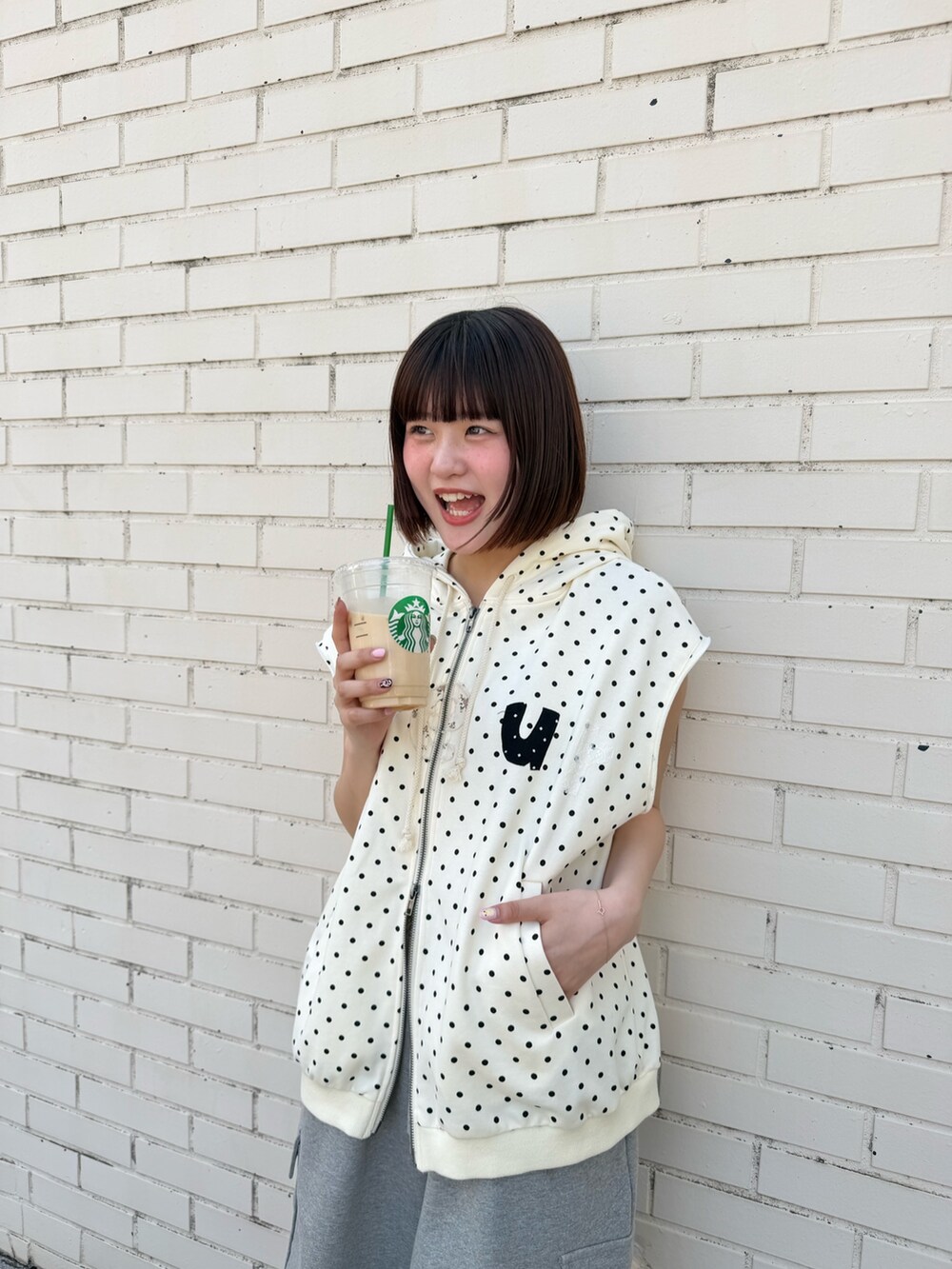 ホワイト系のパーカー、グレー系のその他パンツ、ブラック系のその他シューズを着用したレディースの春コーディネートの3枚目の写真