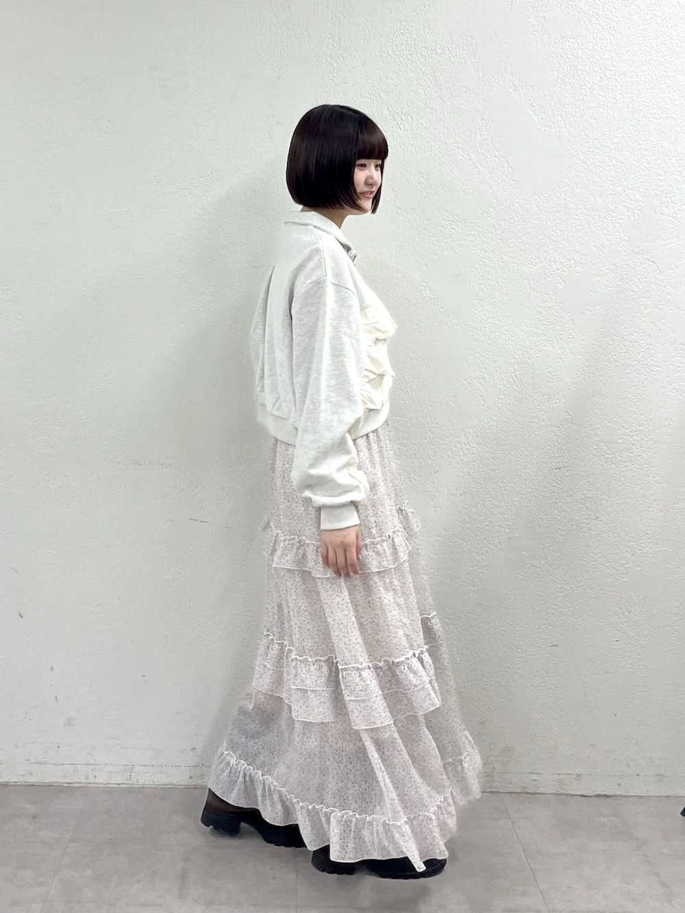 オレンジ系のワンピース、ホワイト系のTシャツ/カットソー、ブラウン系のブーツを着用したレディースの春コーディネートの3枚目の写真