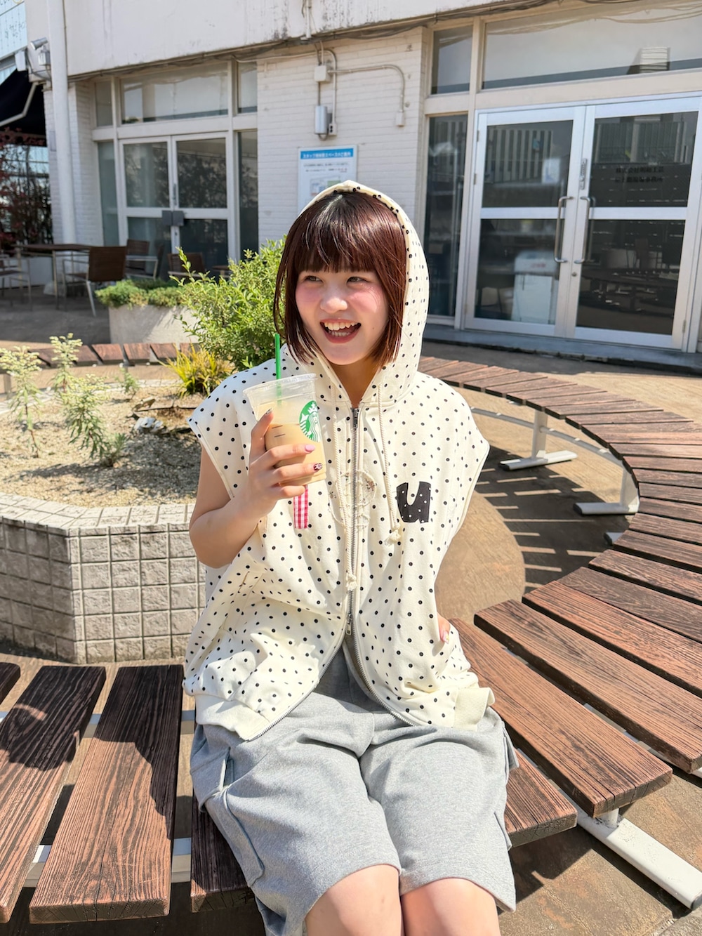 ホワイト系のパーカー、グレー系のその他パンツ、ブラック系のその他シューズを着用したレディースの春コーディネートの5枚目の写真