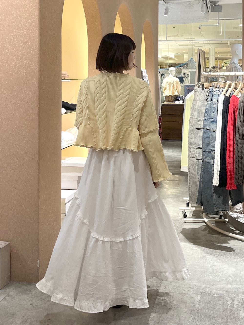 ホワイト系のワンピース、イエロー系のカーディガン/ボレロを着用したレディースの春コーディネートの2枚目の写真