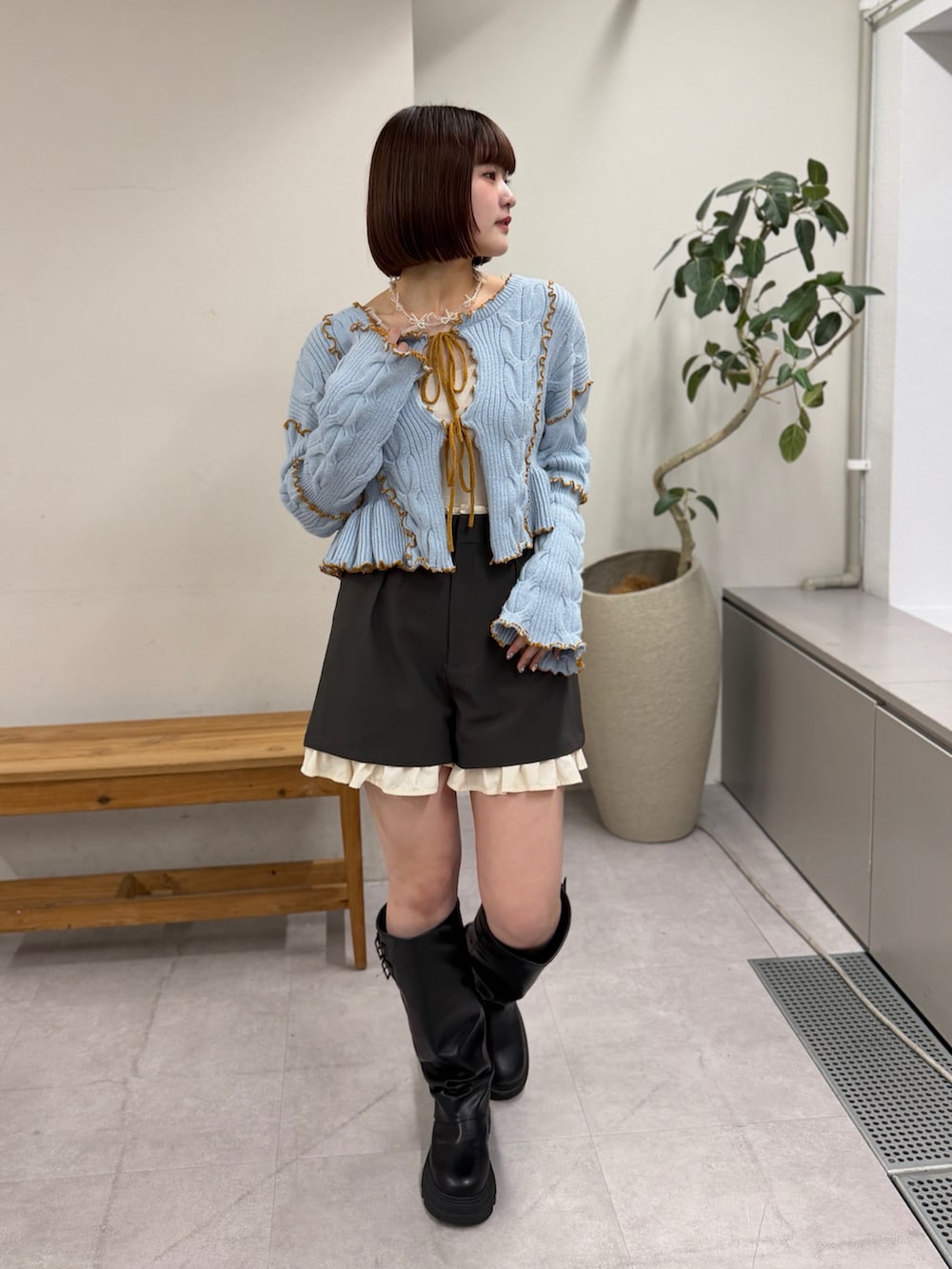 グレー系のその他パンツ、ブルー系のカーディガン/ボレロ、ブラック系のブーツを着用したレディースの冬コーディネートの4枚目の写真