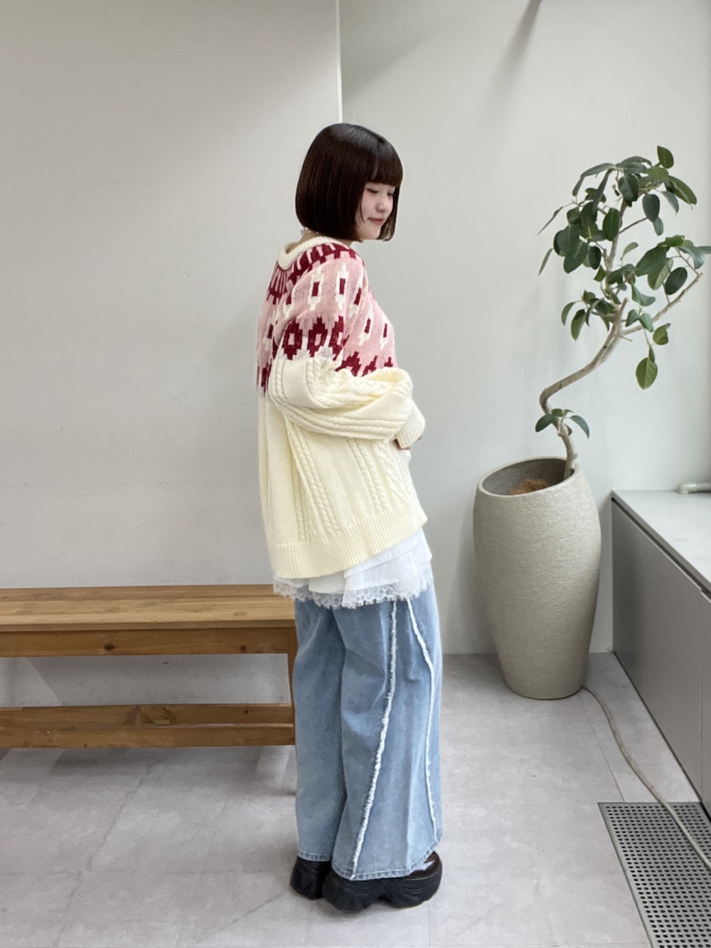 ブルー系のデニムパンツ、レッド系のニット/セーター、ブラウン系のその他シューズを着用したレディースの冬コーディネートの2枚目の写真