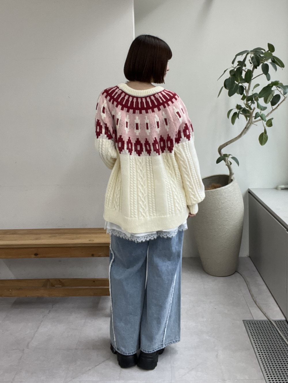 ブルー系のデニムパンツ、レッド系のニット/セーター、ブラウン系のその他シューズを着用したレディースの冬コーディネートの3枚目の写真