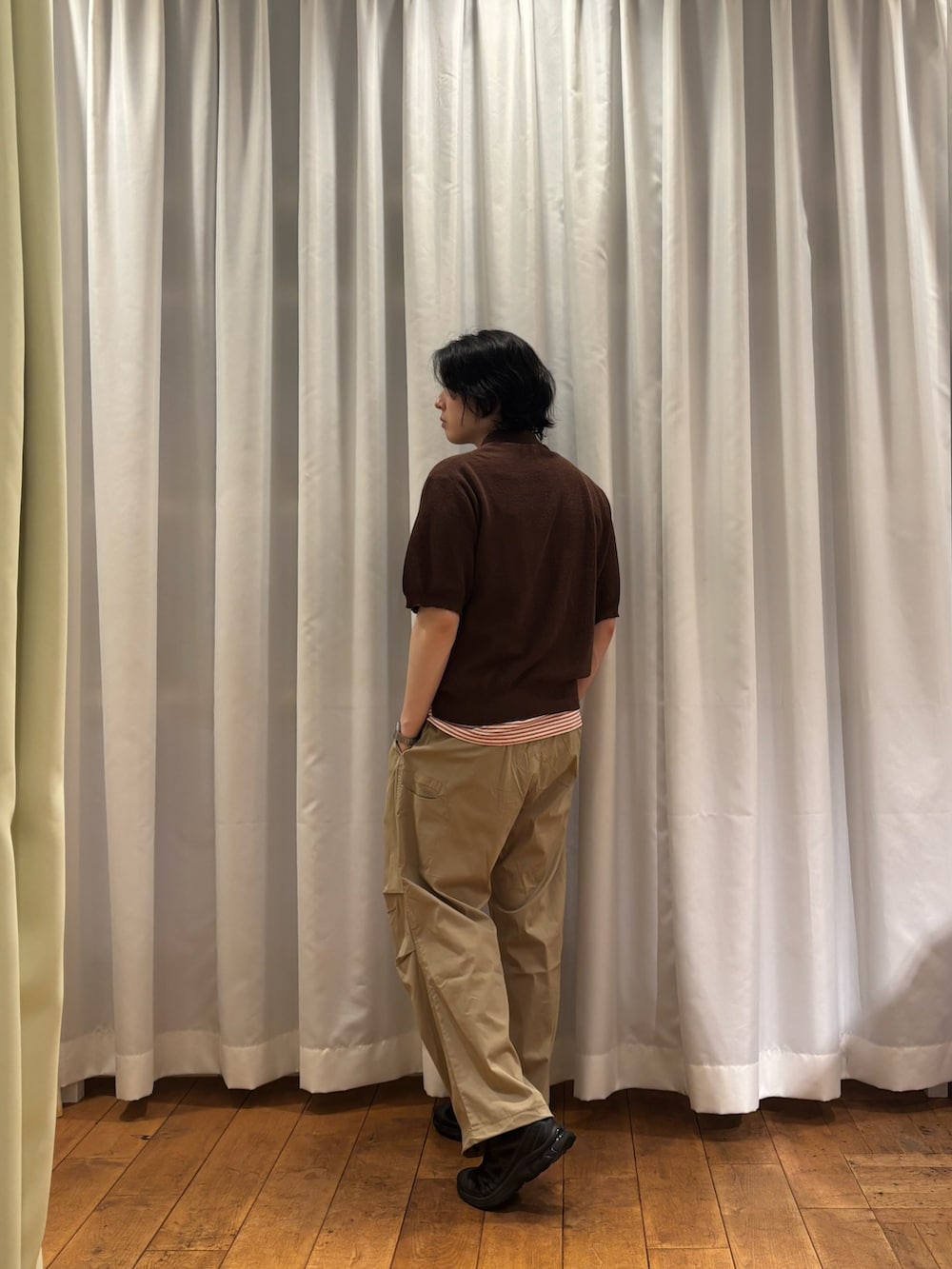 ブラウン系のニット/セーター、レッド系のTシャツ/カットソー、ベージュ系のその他パンツを着用したメンズの夏コーディネートの2枚目の写真