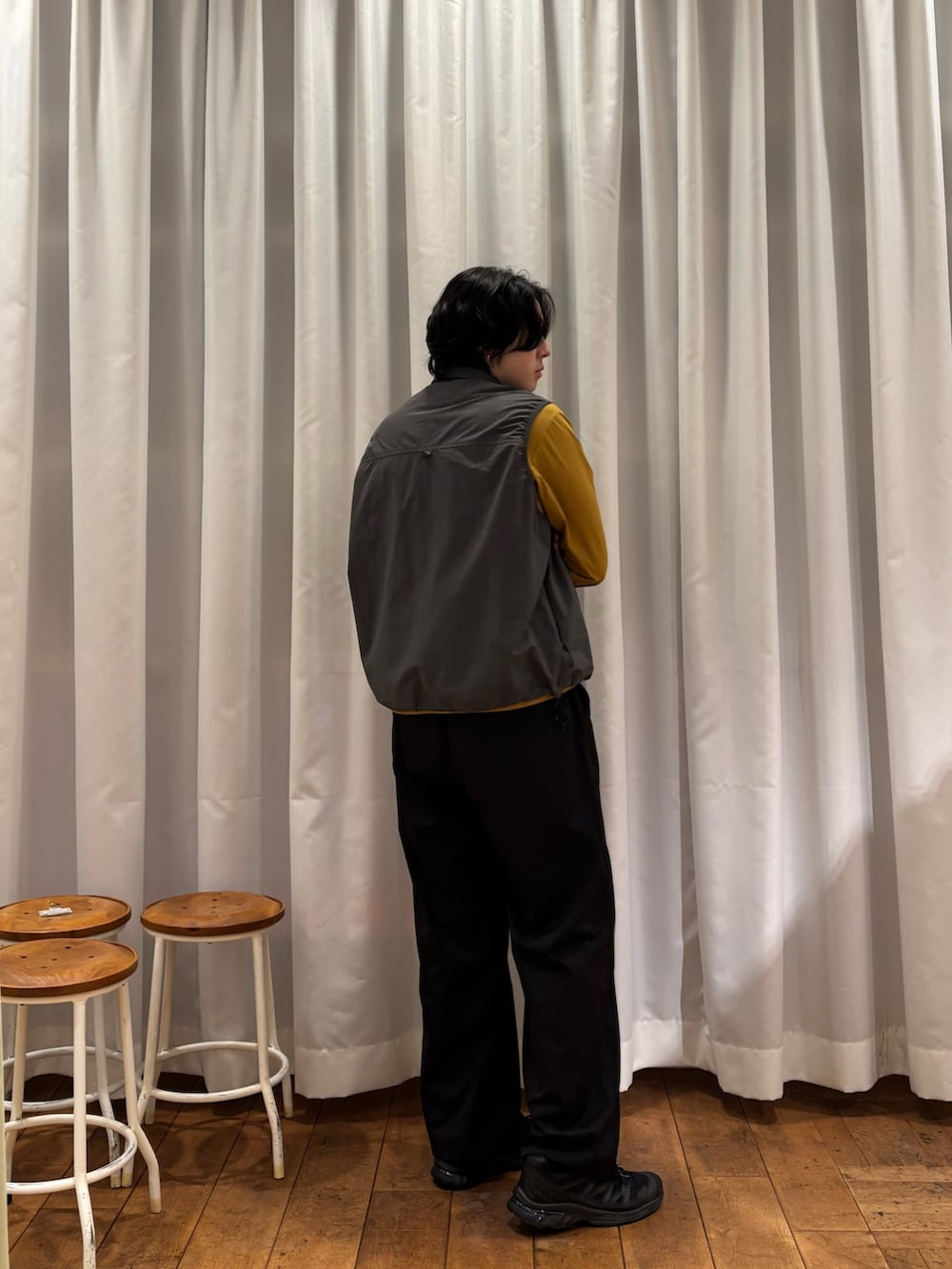 グレー系のベスト、ブラック系のその他パンツを着用したメンズの春コーディネートの4枚目の写真