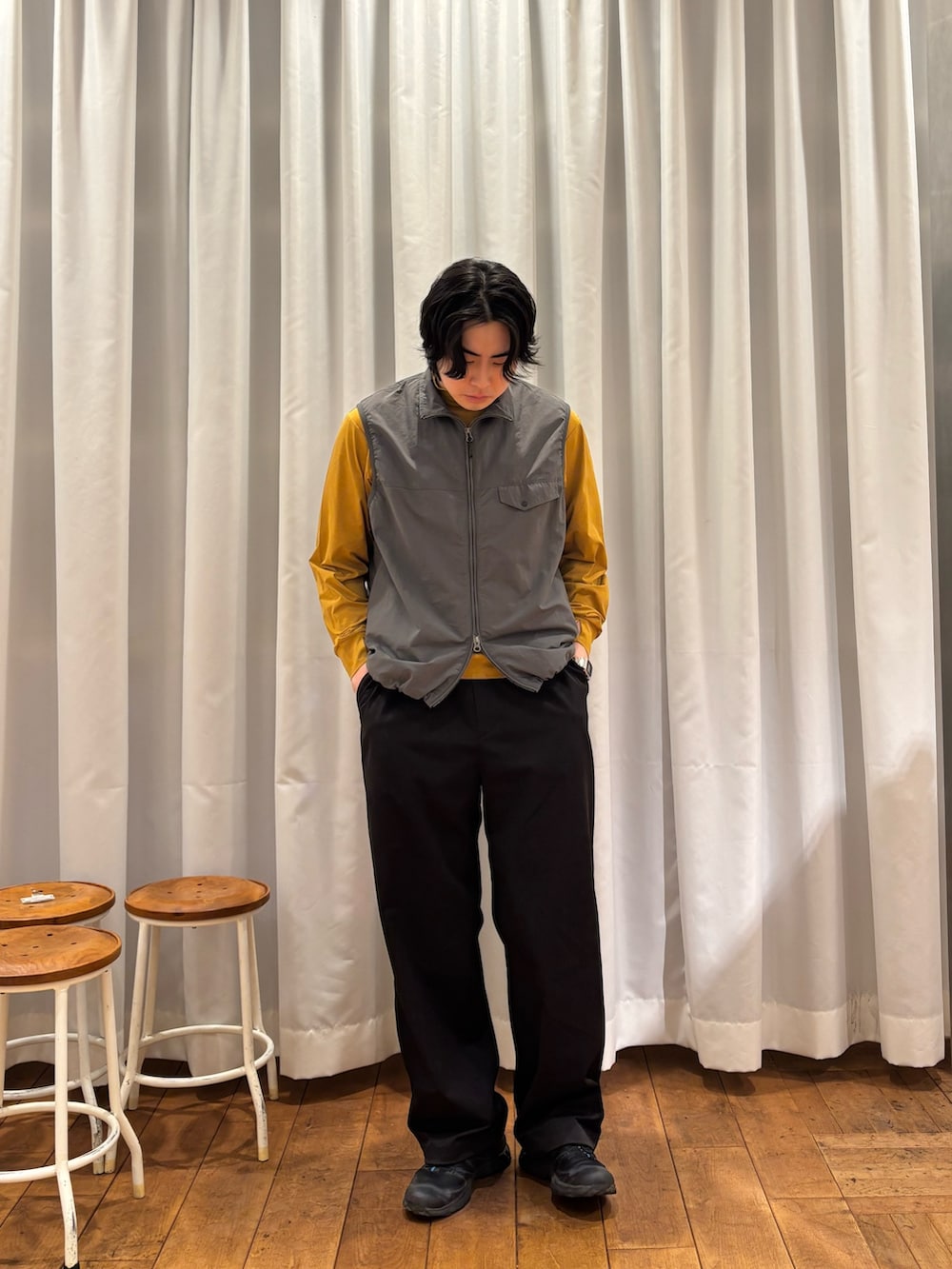 グレー系のベスト、ブラック系のその他パンツを着用したメンズの春コーディネートの3枚目の写真