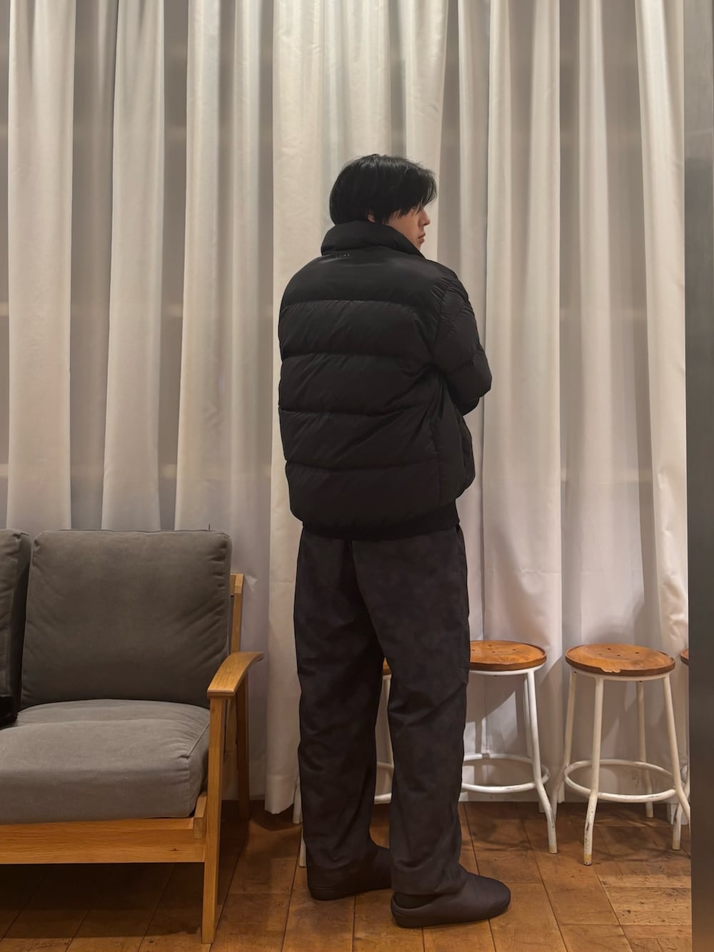 ブラック系のダウンジャケット/コート、ブラック系のその他パンツ、グレー系のその他シューズを着用したメンズの冬コーディネートの2枚目の写真