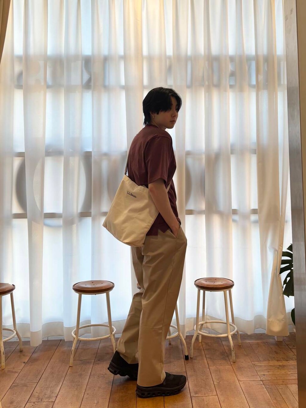 ベージュ系のショルダーバッグ、オレンジ系のTシャツ/カットソーを着用したメンズの夏コーディネートの2枚目の写真