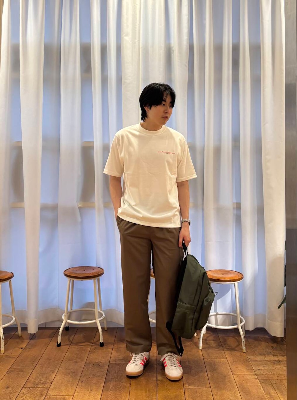 ベージュ系のその他パンツ、ベージュ系のスニーカー、グリーン系のバックパック/リュックを着用したメンズの夏コーディネートの3枚目の写真