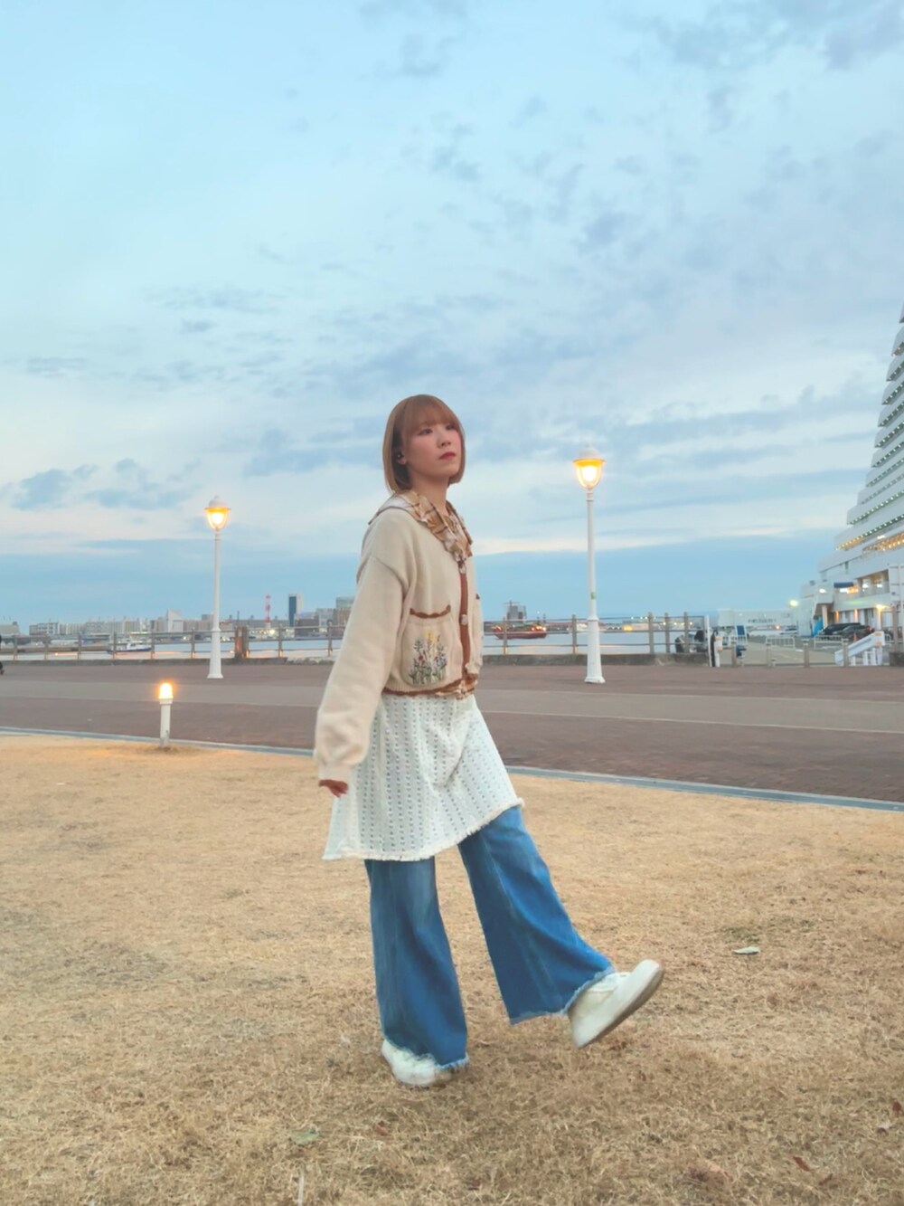 ホワイト系のスニーカー、ブルー系のデニムパンツ、ブラウン系のシャツ/ブラウスを着用したレディースの冬コーディネートの4枚目の写真