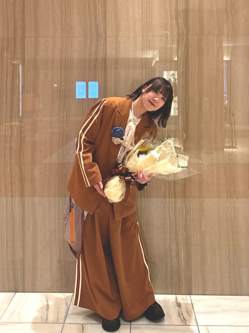 ブラウン系のテーラードジャケット、ブラウン系のスラックス、ホワイト系のシャツ/ブラウスを着用したレディースの春コーディネートの2枚目の写真