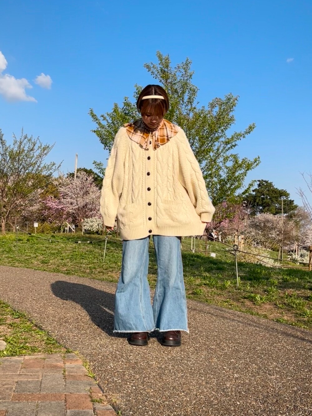 ホワイト系のカーディガン/ボレロ、ブラウン系のシャツ/ブラウス、ブルー系のデニムパンツを着用したレディースの春コーディネートの2枚目の写真