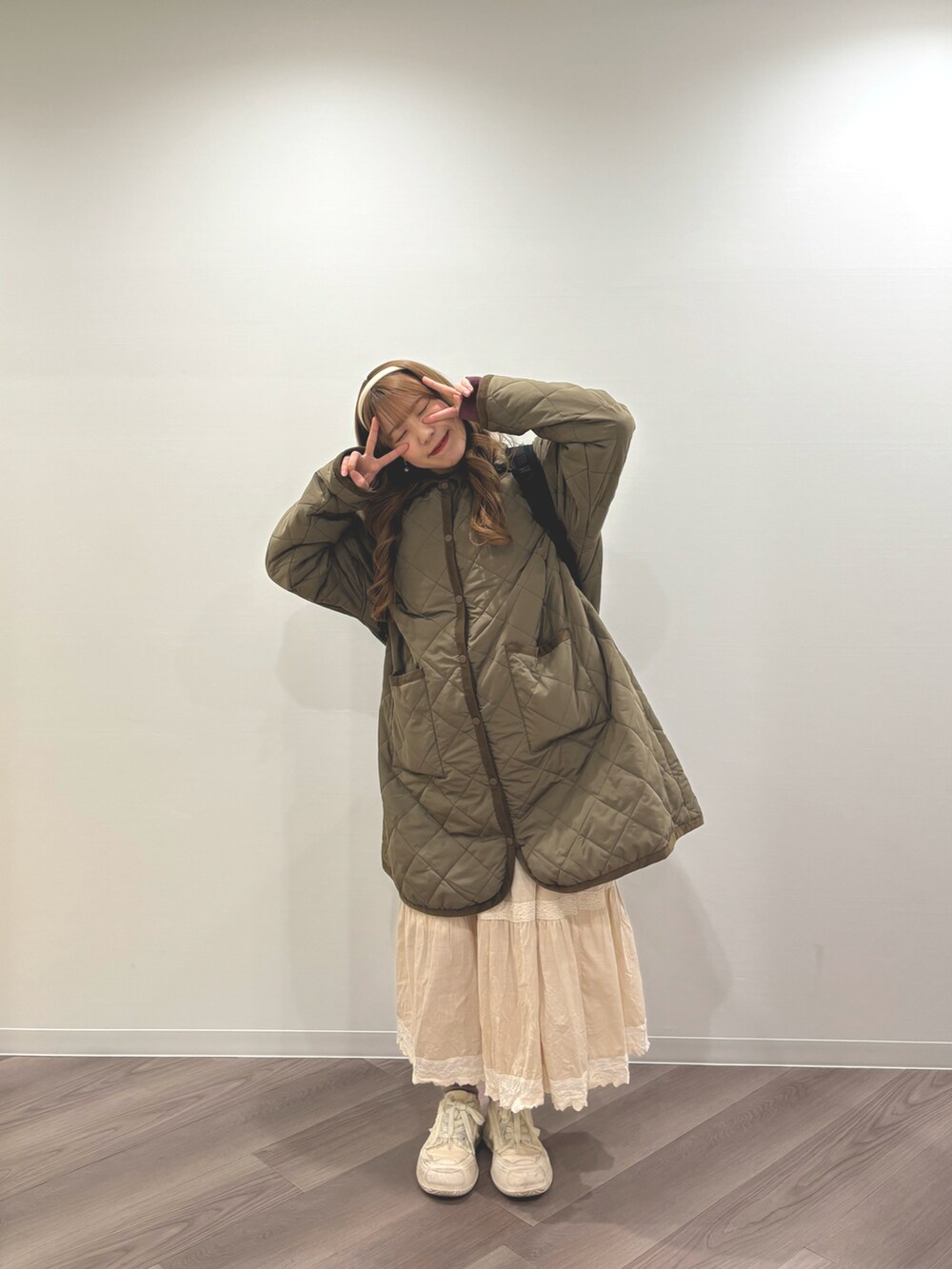 ホワイト系のシューズ、グリーン系のその他アウター、ベージュ系のスカートを着用したレディースの冬コーディネートの2枚目の写真