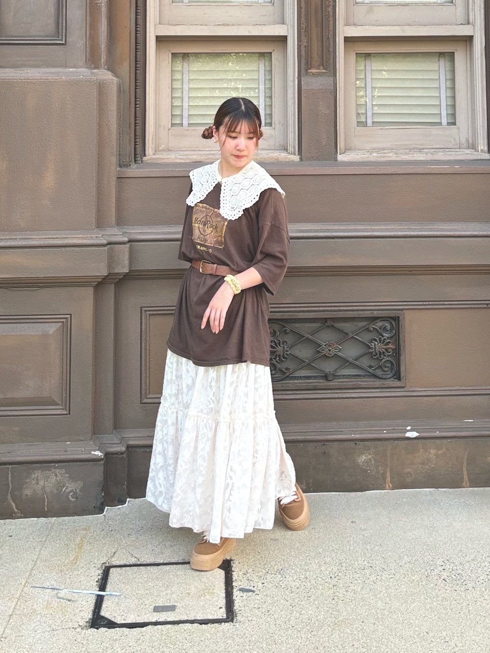 ブラウン系のTシャツ/カットソー、ホワイト系のスカート、ブラウン系のスニーカーを着用したレディースの冬コーディネートの2枚目の写真