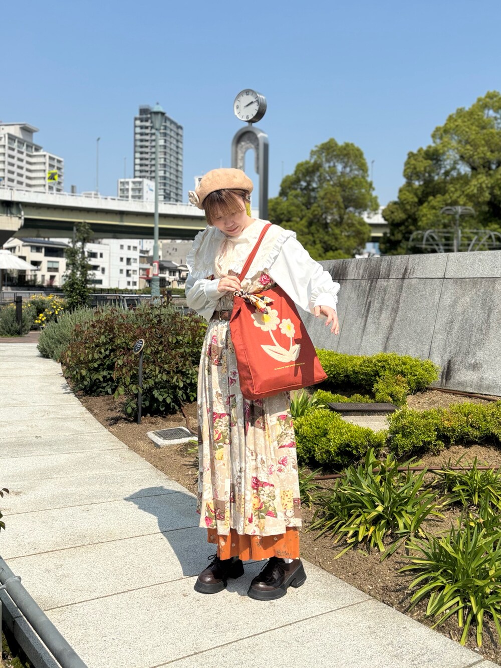 ブラウン系のトートバッグ、ホワイト系のシャツ/ブラウス、ベージュ系のワンピースを着用したレディースの春コーディネートの3枚目の写真