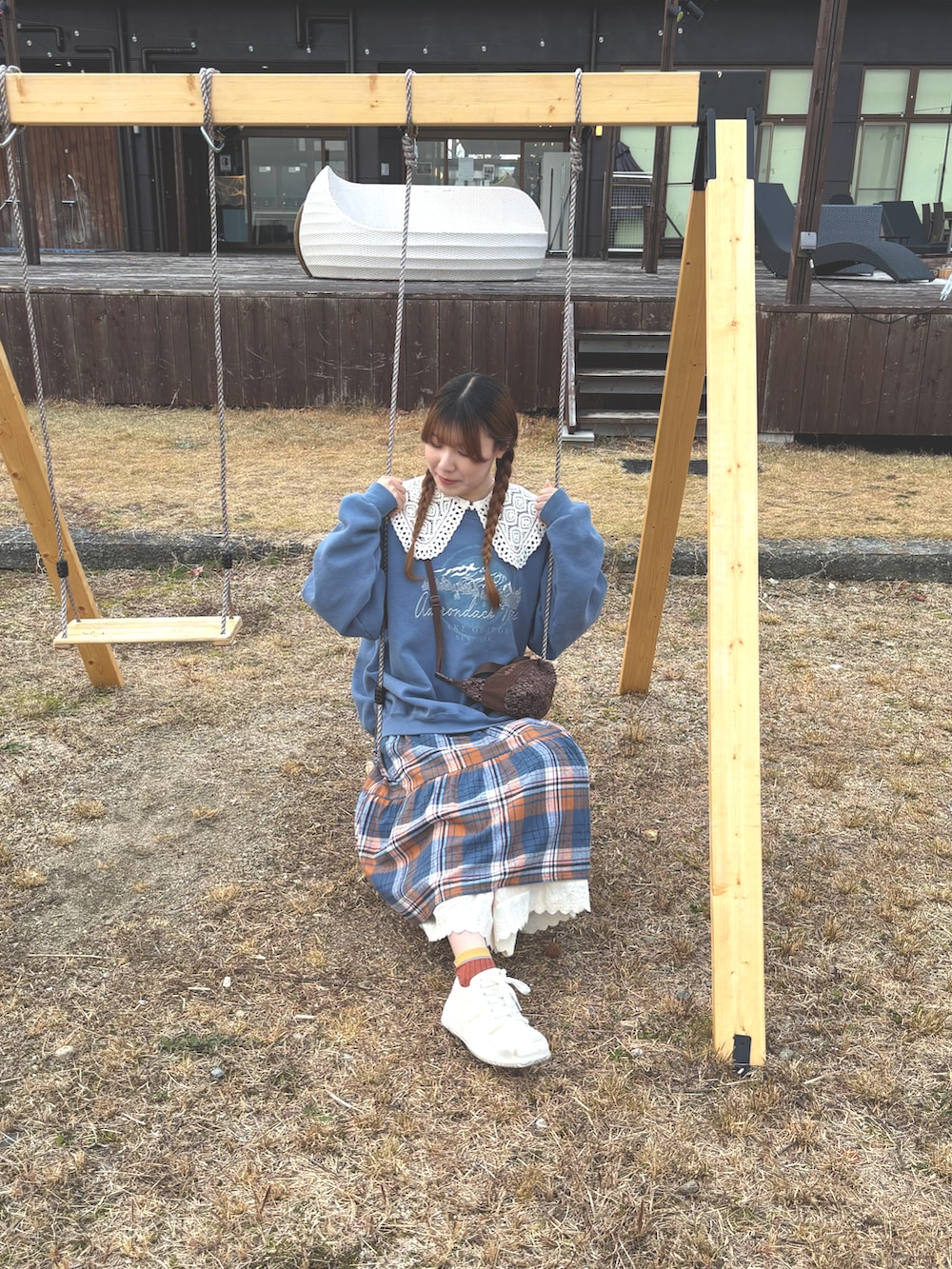 ブラウン系のショルダーバッグ、ブルー系のワンピース、ブルー系のスウェットを着用したレディースの冬コーディネートの3枚目の写真