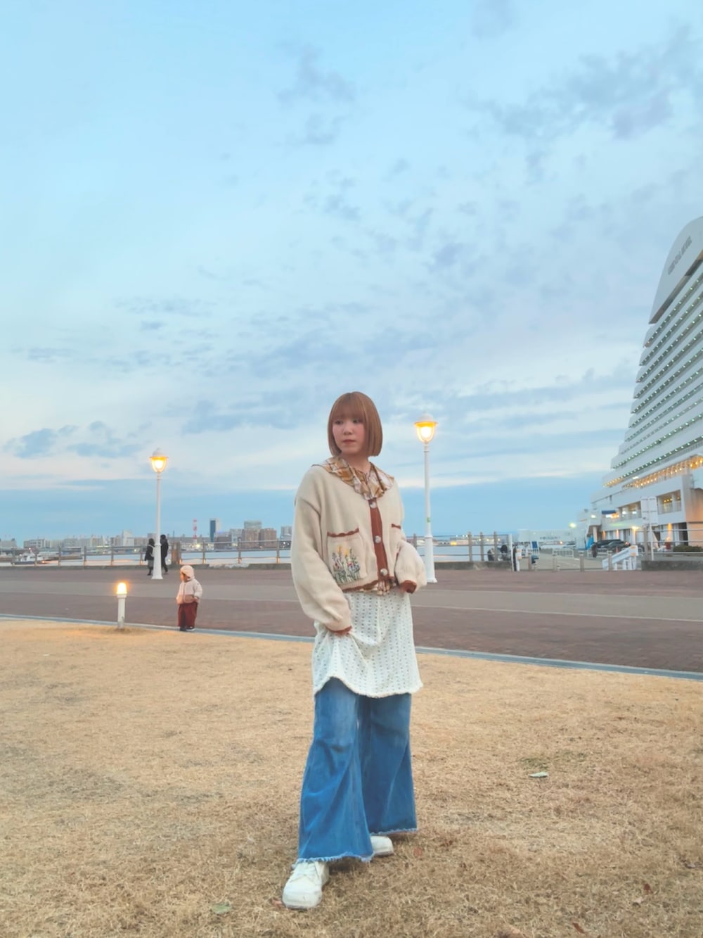 ホワイト系のスニーカー、ブルー系のデニムパンツ、ブラウン系のシャツ/ブラウスを着用したレディースの冬コーディネートの2枚目の写真