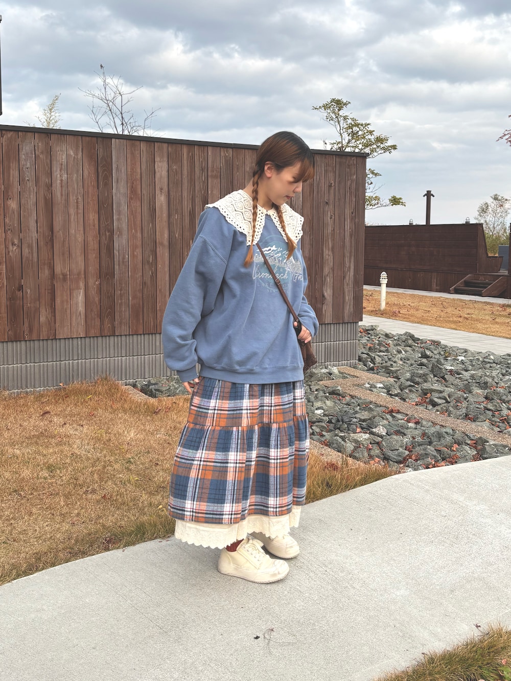 ブラウン系のショルダーバッグ、ブルー系のワンピース、ブルー系のスウェットを着用したレディースの冬コーディネートの2枚目の写真