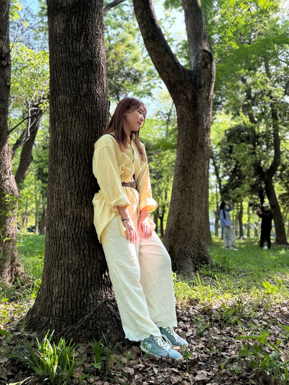 イエロー系のシャツ/ブラウス、ホワイト系のパンツ、ブラウン系のショルダーバッグを着用したレディースの冬コーディネートの4枚目の写真