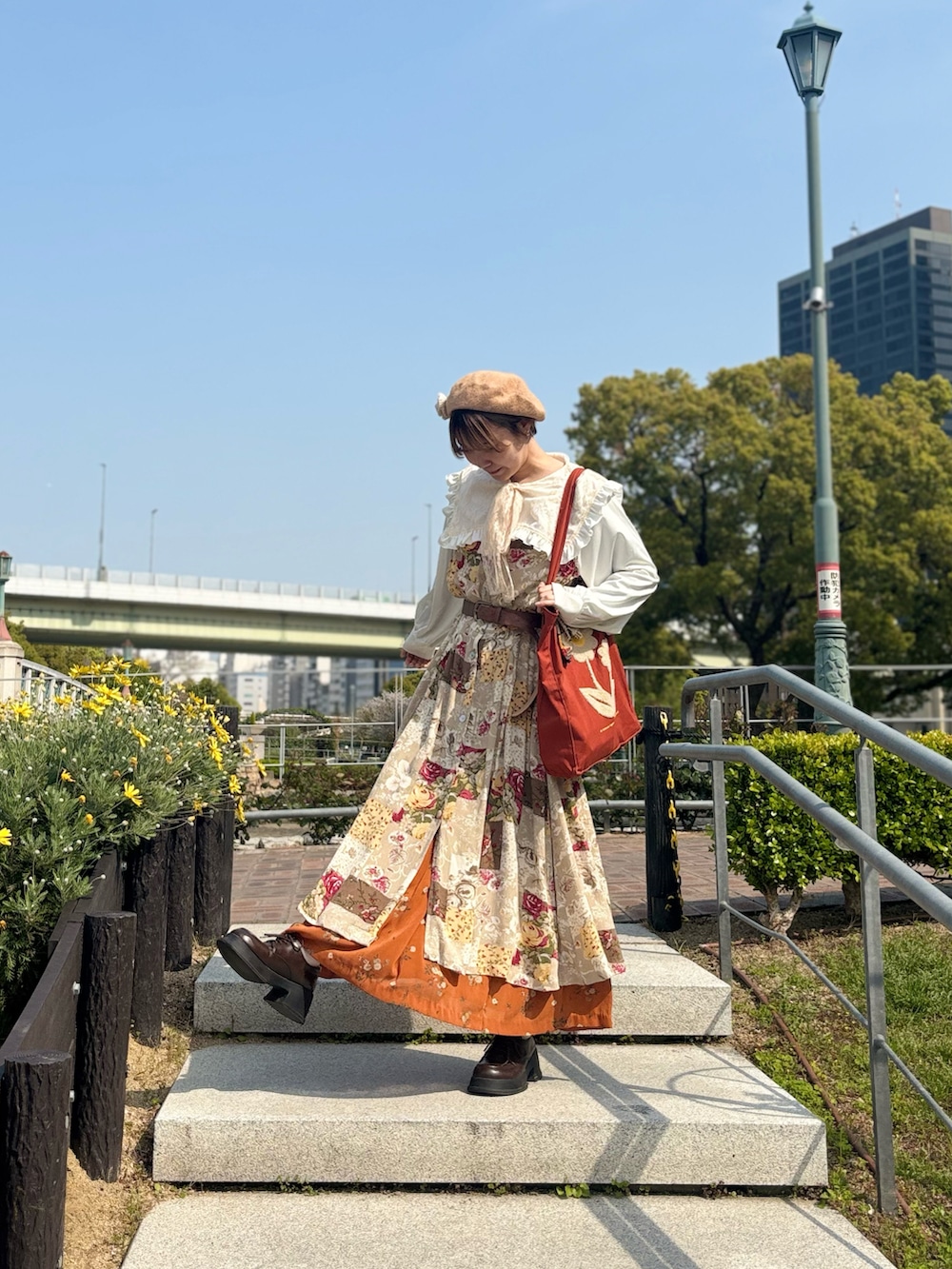 ブラウン系のトートバッグ、ホワイト系のシャツ/ブラウス、ベージュ系のワンピースを着用したレディースの春コーディネートの2枚目の写真