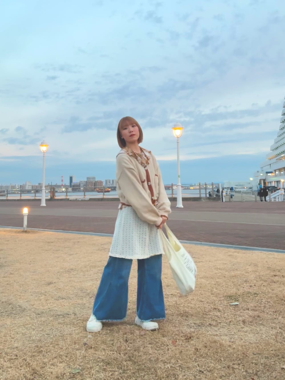 ホワイト系のスニーカー、ブルー系のデニムパンツ、ブラウン系のシャツ/ブラウスを着用したレディースの冬コーディネートの3枚目の写真