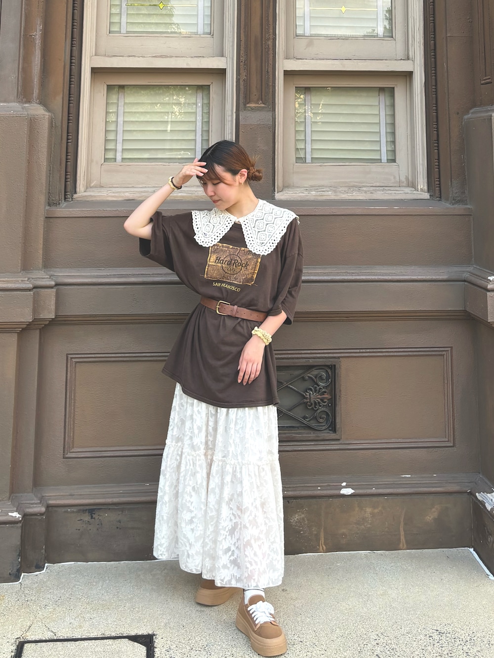 ブラウン系のTシャツ/カットソー、ホワイト系のスカート、ブラウン系のスニーカーを着用したレディースの冬コーディネートの3枚目の写真