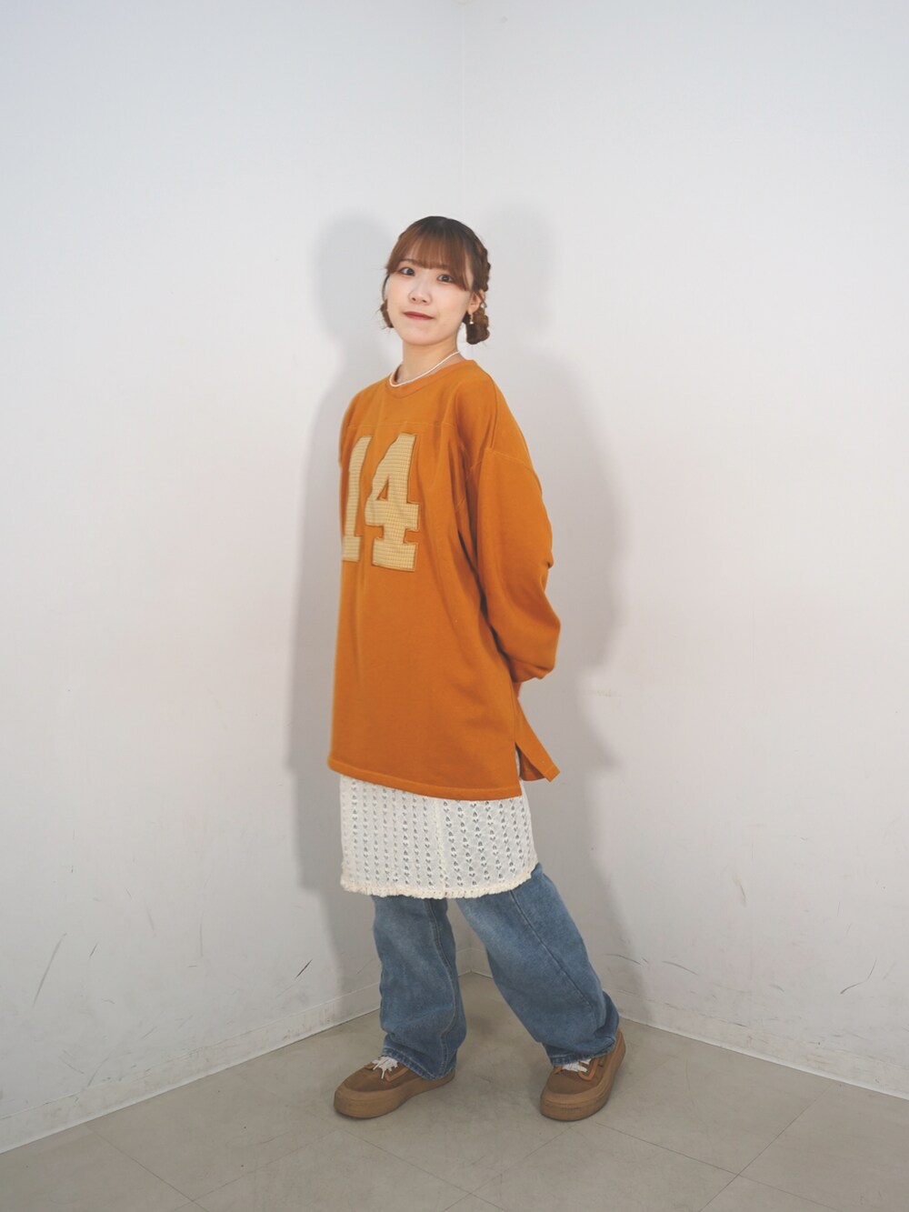 オレンジ系のスウェット、ベージュ系のスカート、ブラウン系のシューズを着用したレディースの冬コーディネートの5枚目の写真