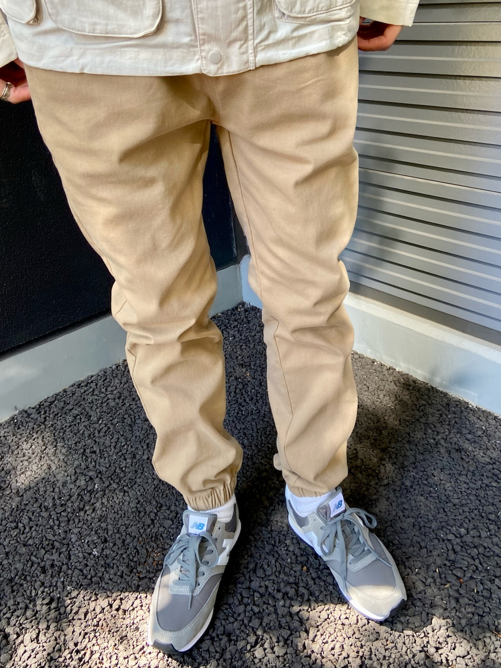 ベージュ系のマウンテンパーカー、ベージュ系のその他パンツ、グレー系のスニーカーを着用したメンズの冬コーディネートの3枚目の写真