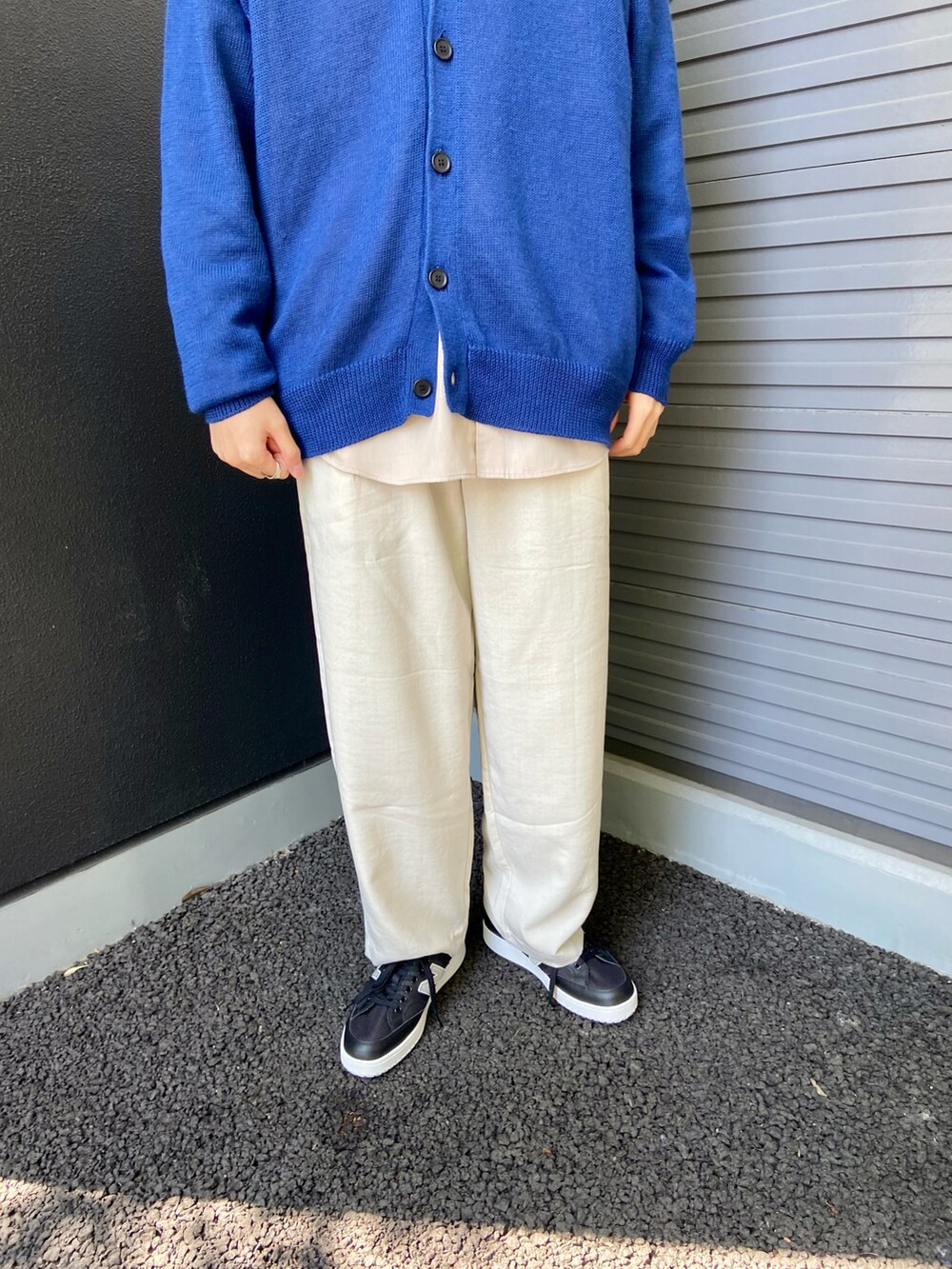 ブルー系のカーディガン/ボレロ、ベージュ系のシャツ/ブラウス、ホワイト系のスラックスを着用したメンズの春コーディネートの3枚目の写真