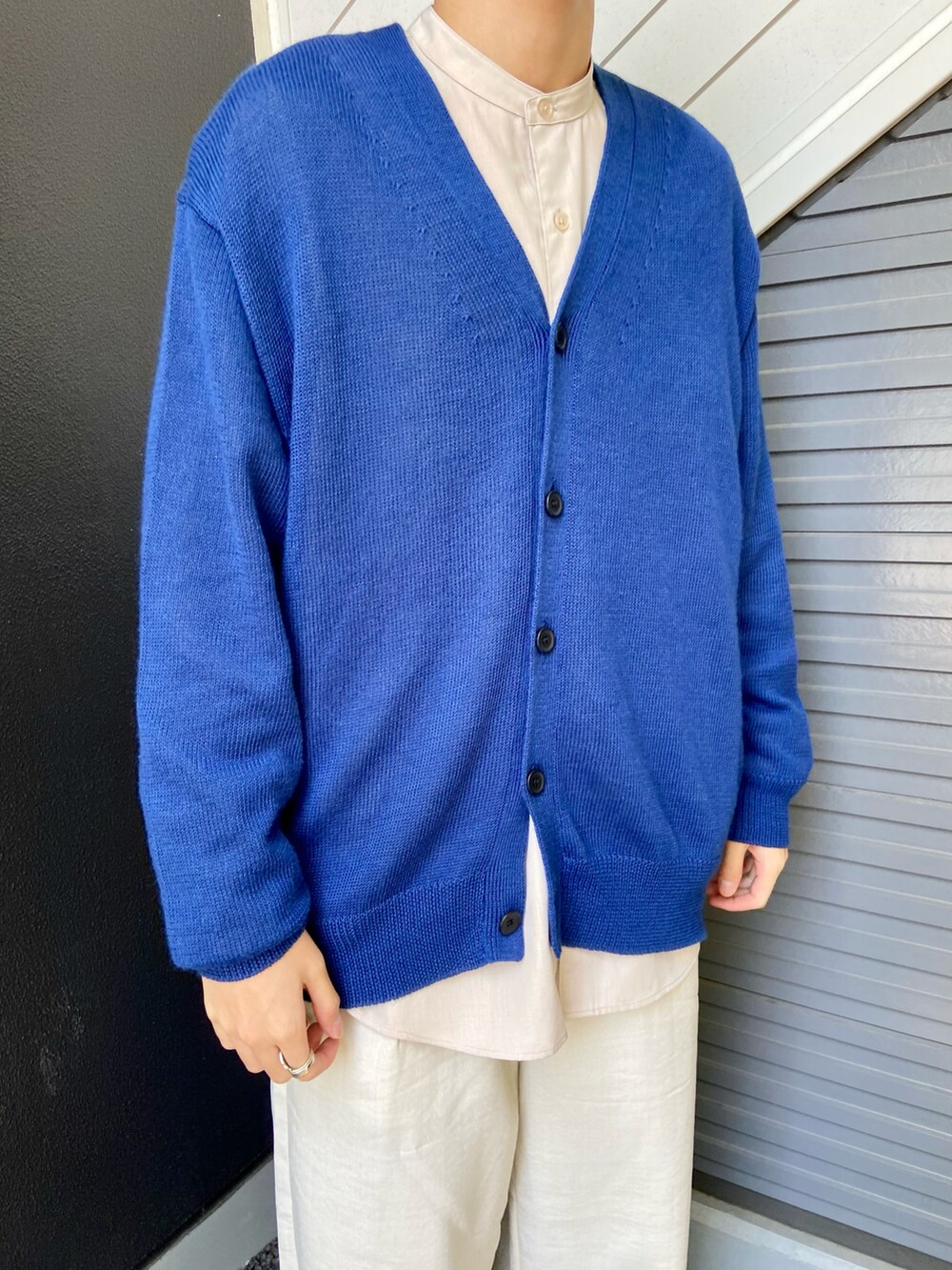 ブルー系のカーディガン/ボレロ、ベージュ系のシャツ/ブラウス、ホワイト系のスラックスを着用したメンズの春コーディネートの2枚目の写真